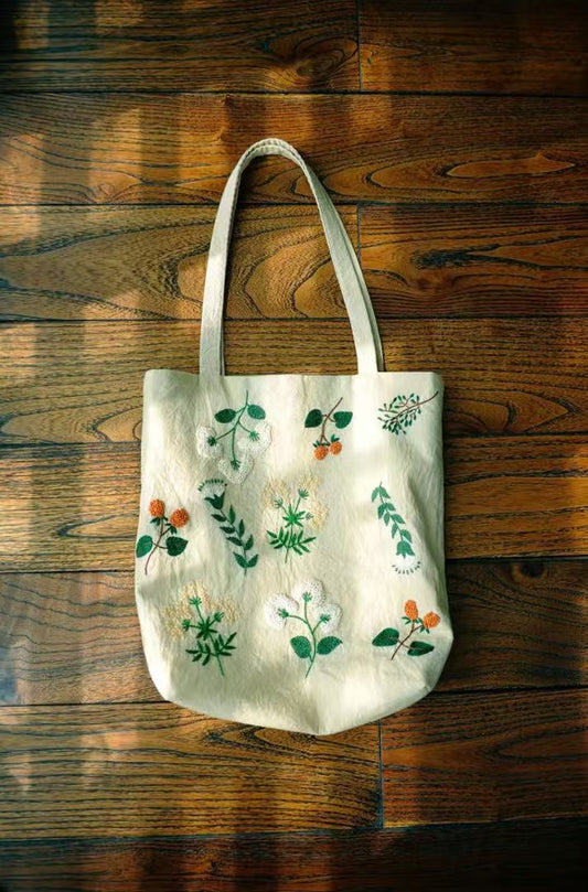 Eco-conscious cotton tote bag with hand-stitched patchwork details, placed on a wooden table