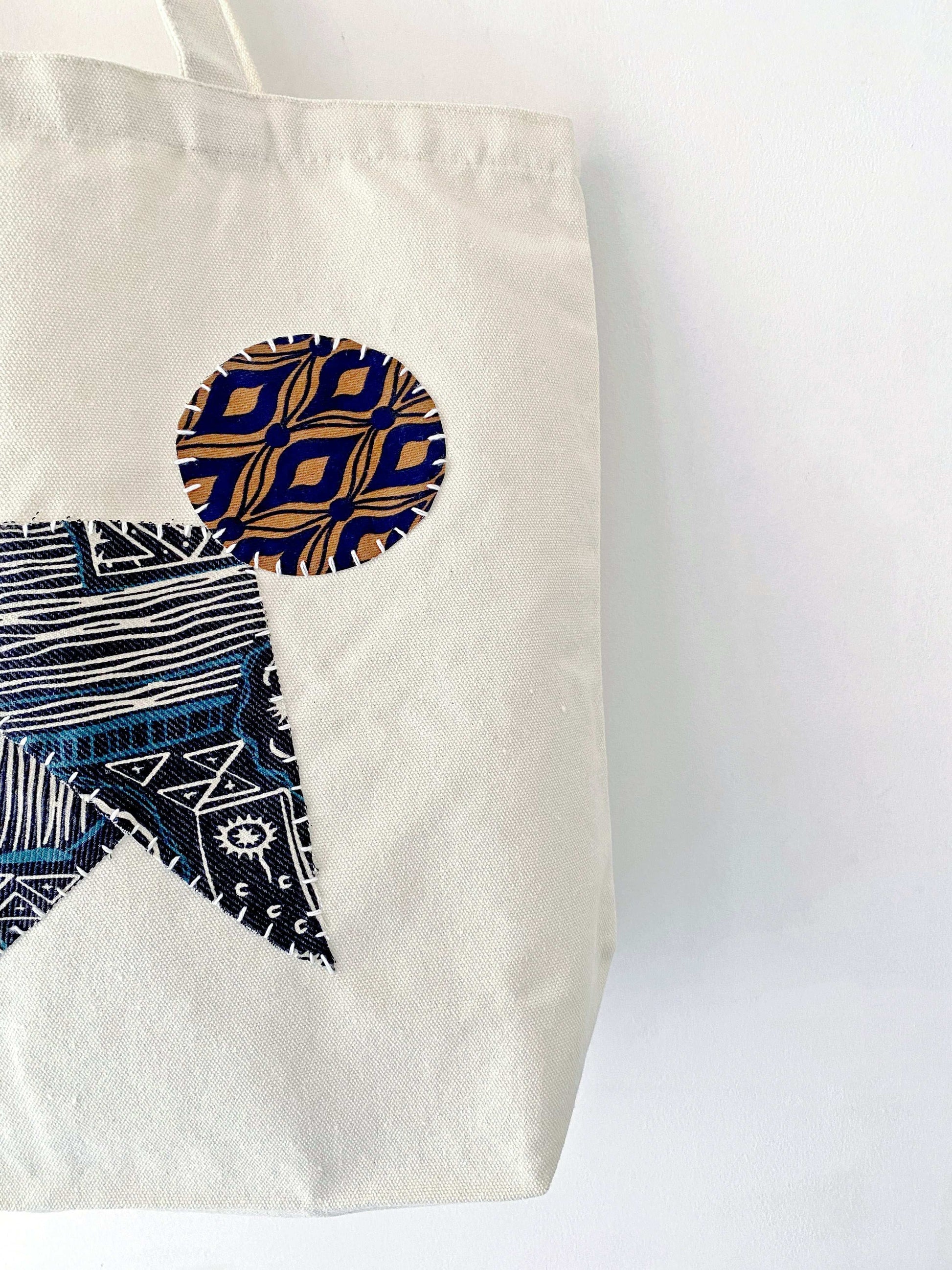 Natural fabric tote with simple design and hand-sewn patchwork detail