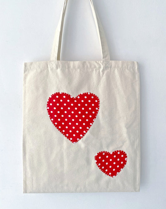 Detail of a hand-stitched embroidery design on a cotton canvas bag, showing the intentional imperfections of the subtle, unique art.