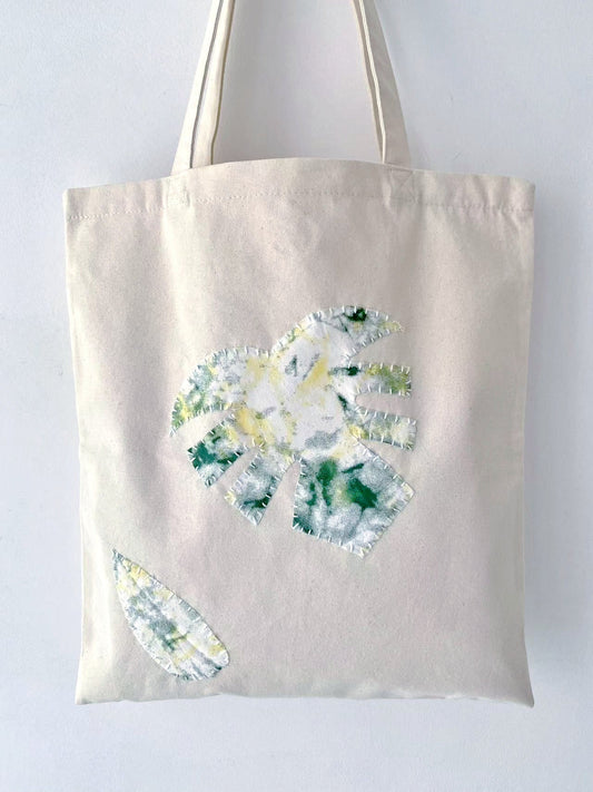 Close-up of patchwork canvas bag and handwritten typography tote in everyday use