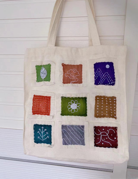 Hand-painted artisan natural fabric bag displayed as a unique sustainable gift