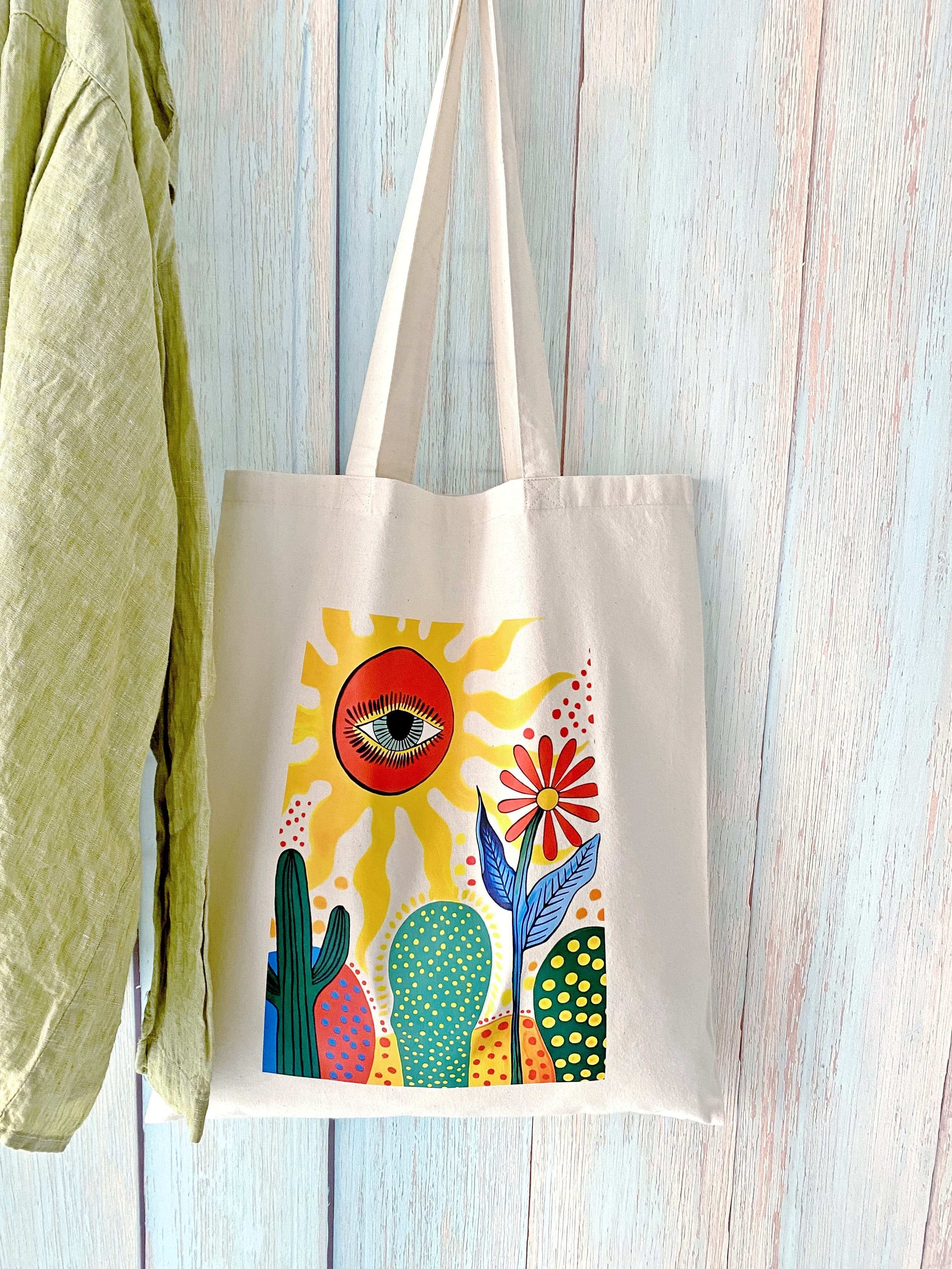 Durable large-capacity cotton bag featuring an artistic cactus sun design, suitable for everyday carry or thoughtful gifting.