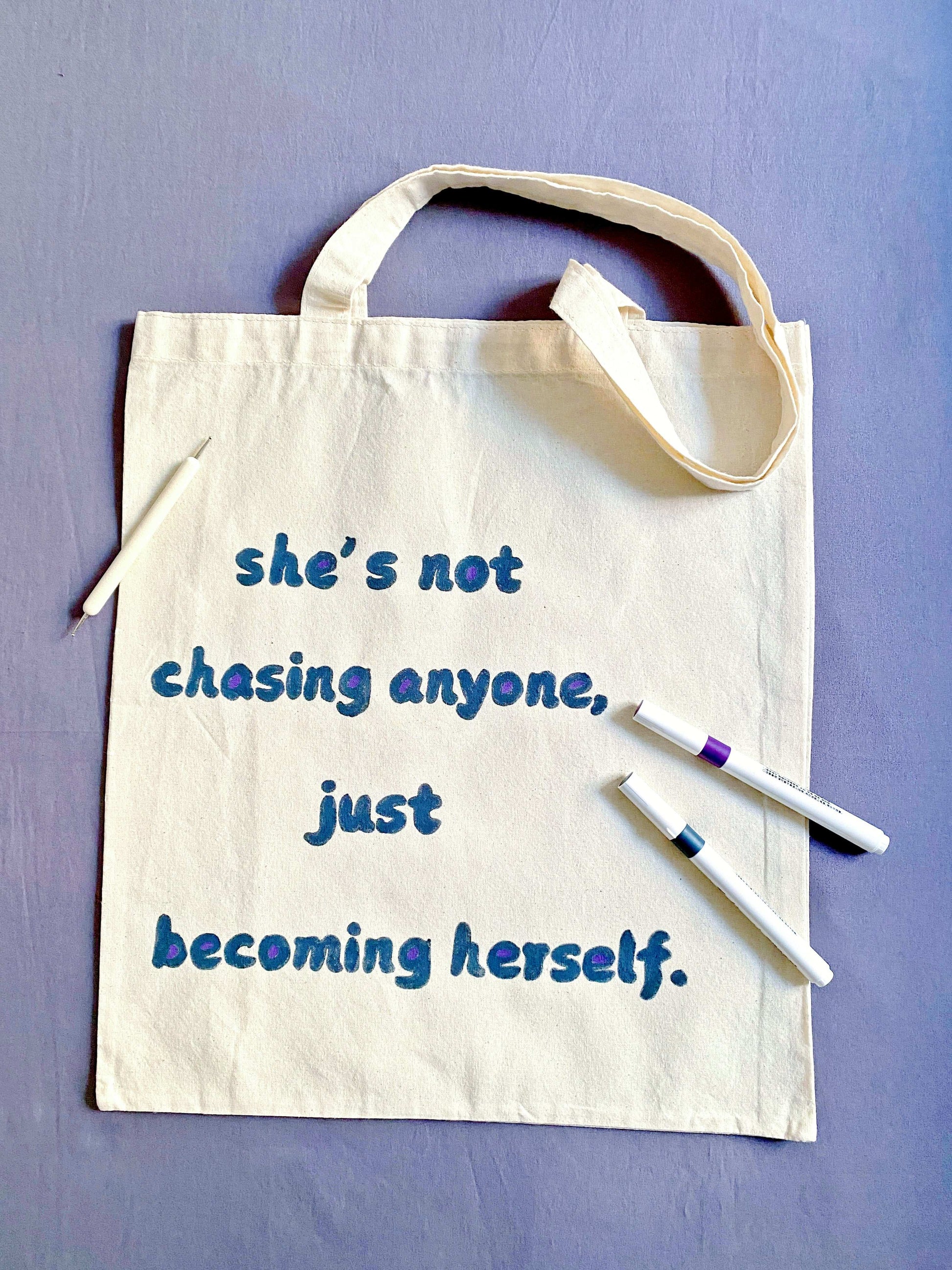 Minimalist cotton tote bag with a positive hand-painted message, perfect for a sustainable and stylish lifestyle.
