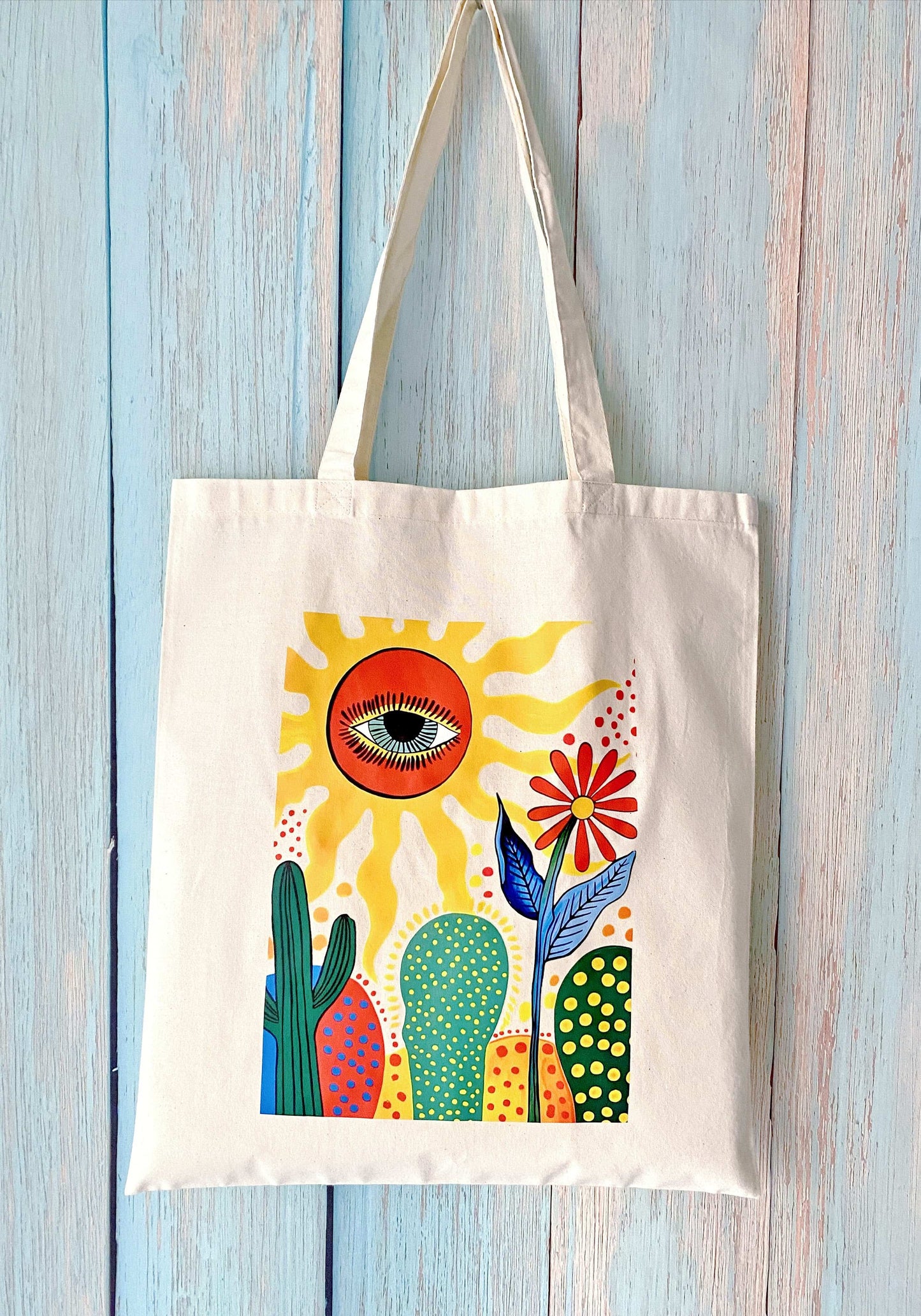 Soft and durable eco cotton shoulder tote featuring a unique sun and cactus flower print, ideal for slow living and thoughtful gifting occasions.