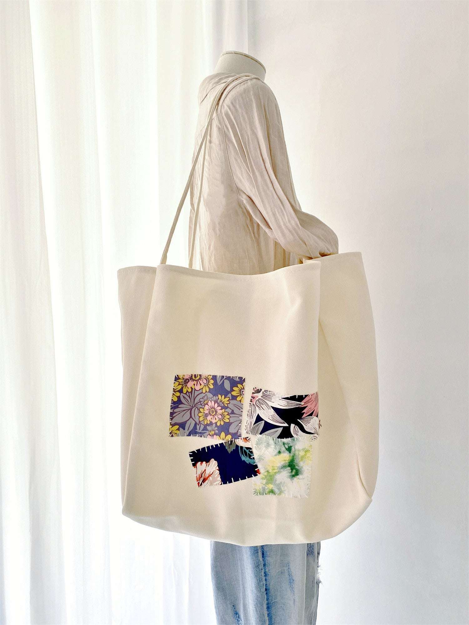 Simple yet spacious tote bag in natural canvas, adorned with unique handcrafted patchwork for mindful fashion choices