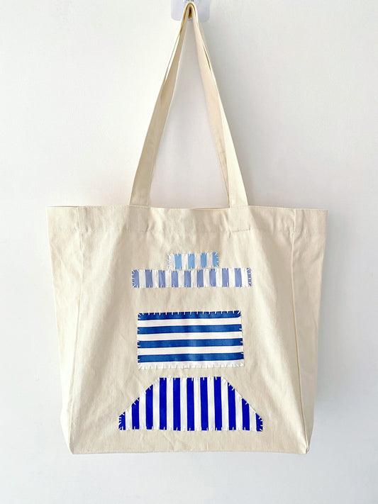 Woman strolling with a spacious cotton tote featuring unique hand-stitched patchwork for everyday errands