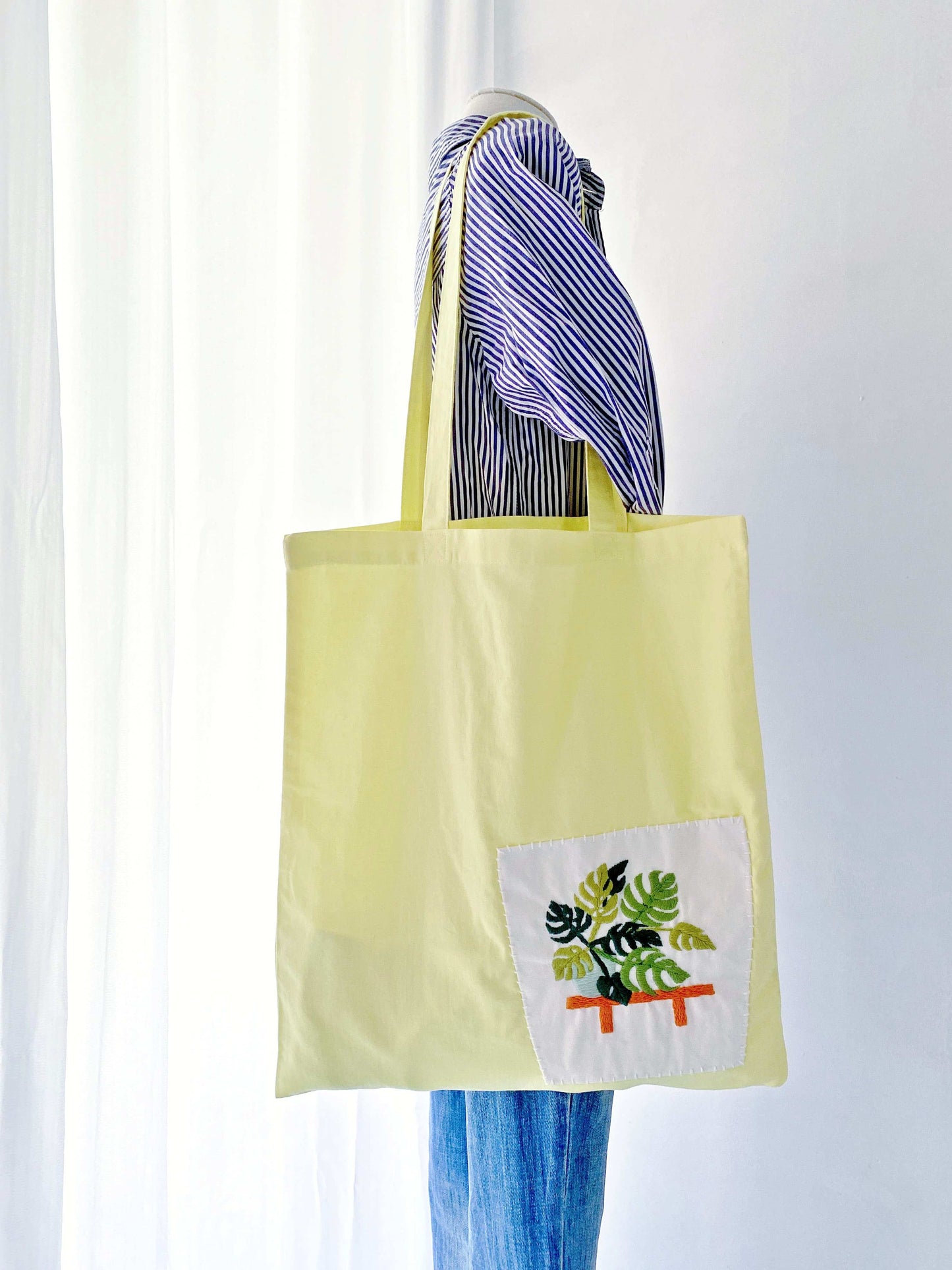 eco-friendly yellow cotton tote bag with embroidered green plant design