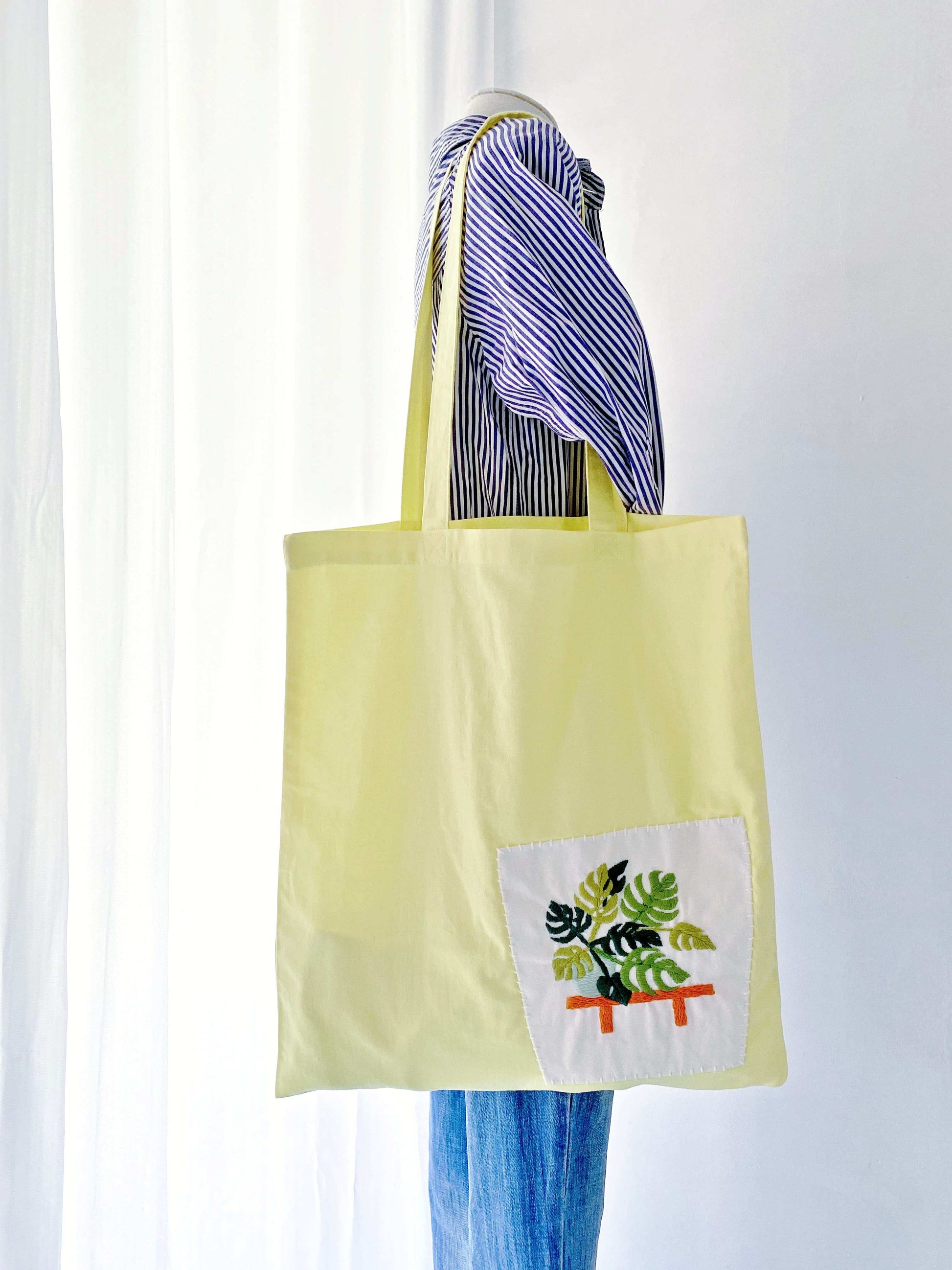 eco-friendly yellow cotton tote bag with embroidered green plant design
