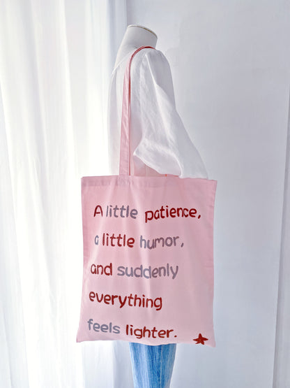 Eco-friendly lightweight tote in pink with a relaxed shape and hand-written text accent