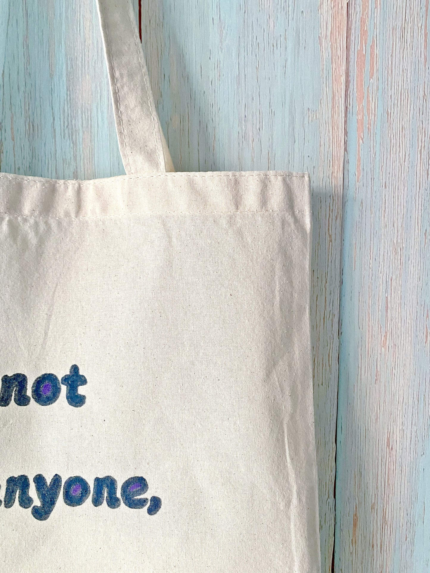 Durable cotton tote bag with a hand-painted motivational phrase, perfect for minimalists who value style and sustainability.