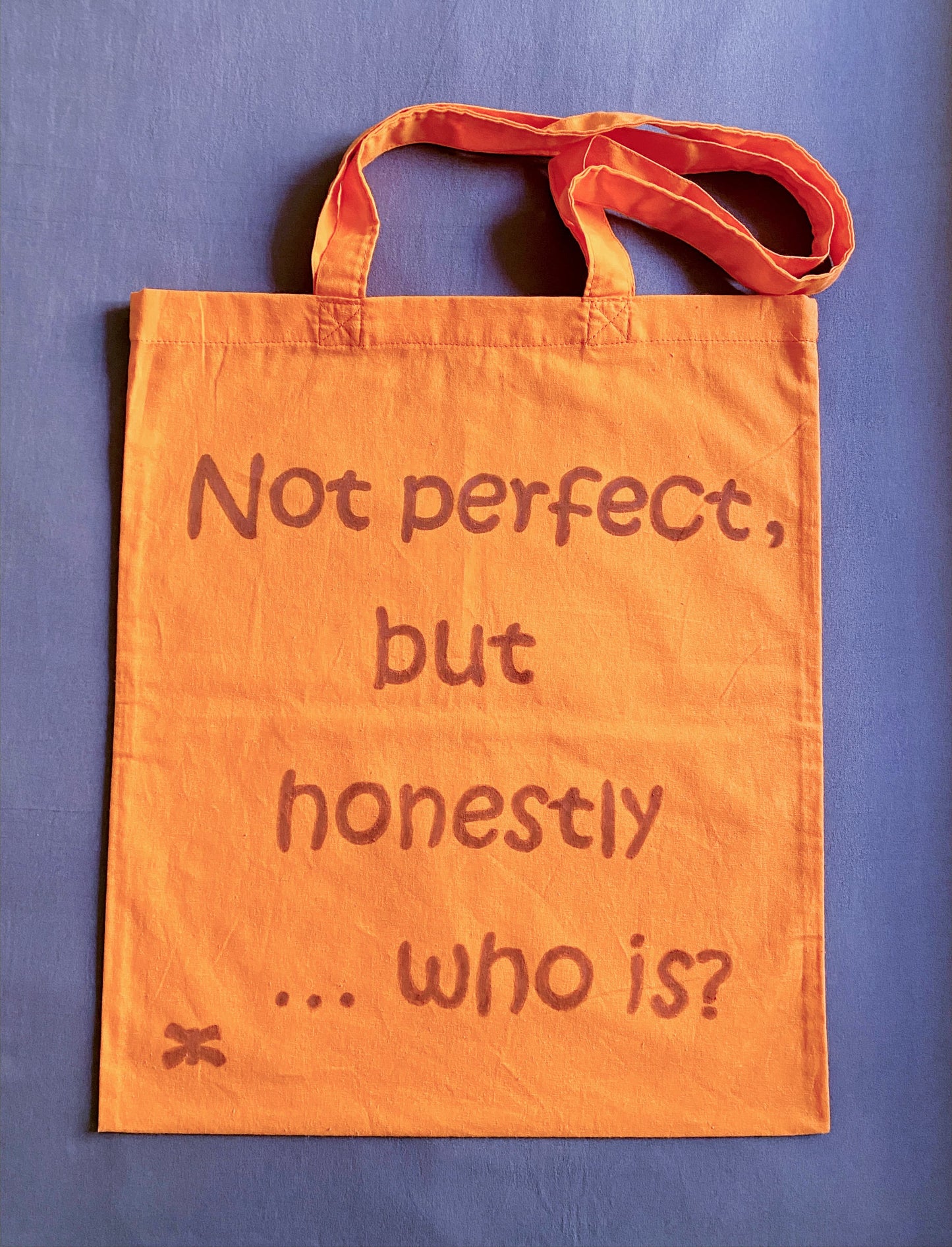 orange cotton tote featuring a handwritten English text detail