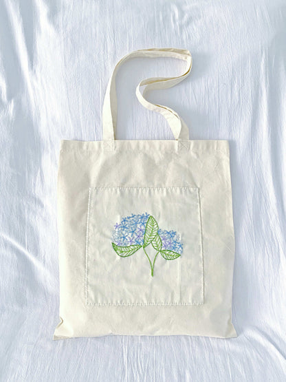 lightweight cotton bag with playful hand embroidered elements
