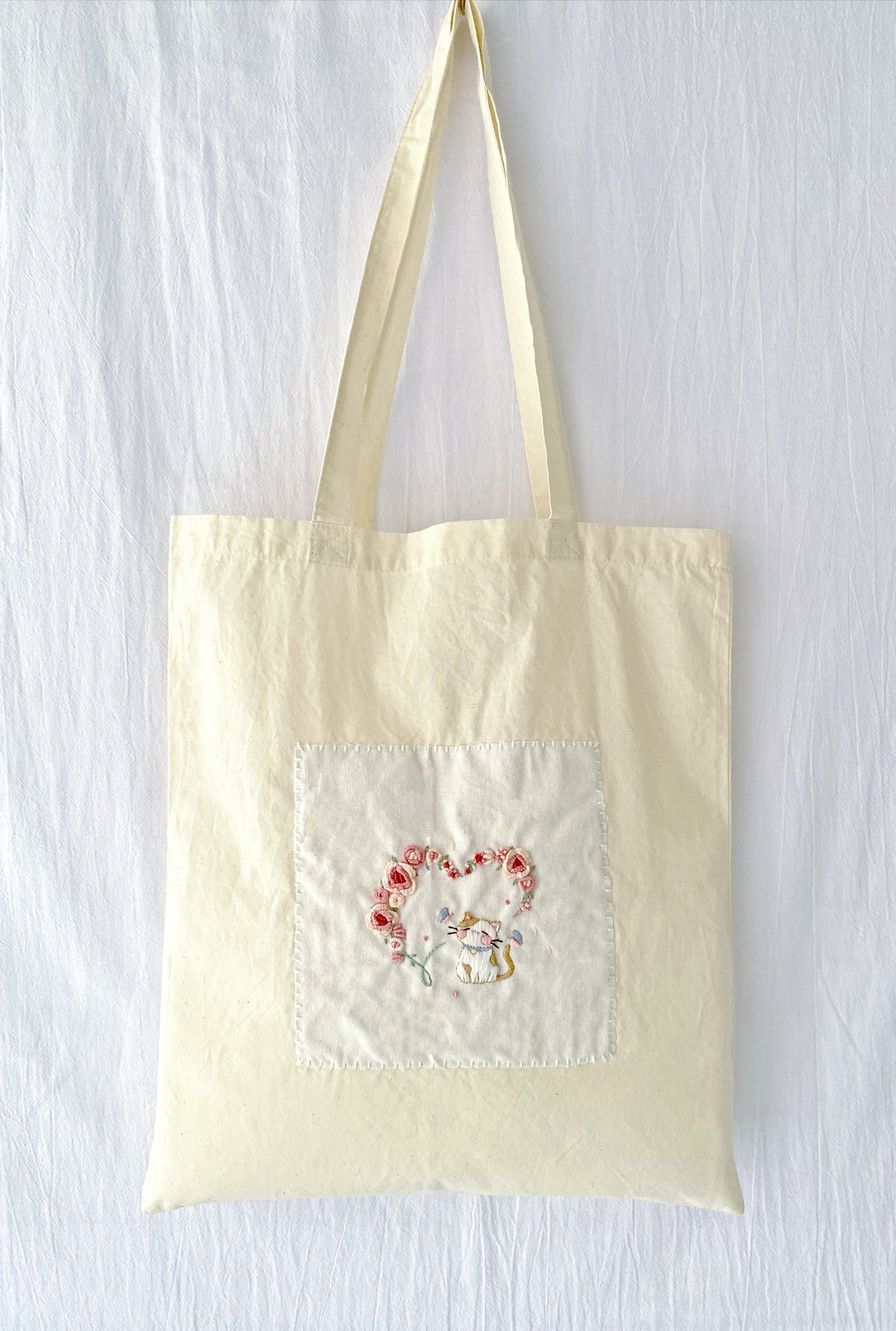 natural material tote bag with delicate floral stitching for daily carry
