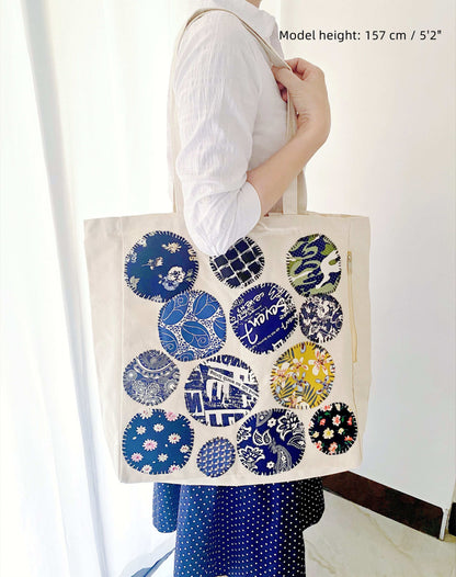 Spacious shoulder tote from cotton, highlighting artisanal stitched motifs for personalized style