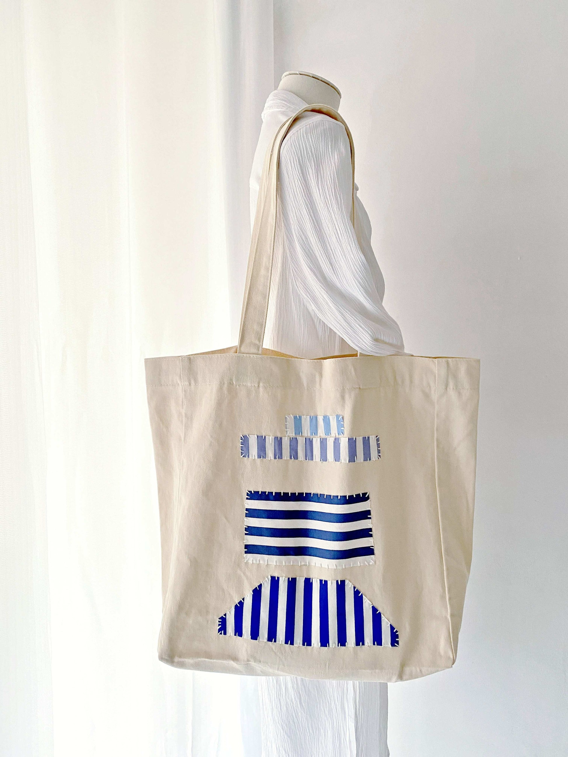 Large capacity tote in sustainable materials, adorned with handmade patchwork for a minimalist vibe